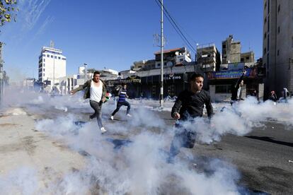 Palestinos huyen de las granadas de gas lacrimógeno disparadas por las tropas israelíes durante los enfrentamientos en la ciudad cisjordana de Belén.
