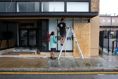 Jeff Hicks and Chris Ahern secure their business ahead of Hurricane Milton's landfall in downtown Tampa, Florida, U.S., on October 8, 2024. 