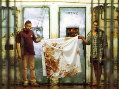 Detentos mostram panos sujos de sangue após o massacre, em outubro de 1992. 