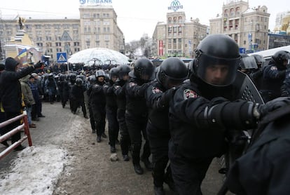 Una l&iacute;nea de polic&iacute;as ucranianos antidisturbios se mueven por la Plaza de la Independencia en Kiev.