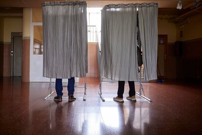 Dos electores en la cabina de votaciones en el IES Cervantes de Granada.
