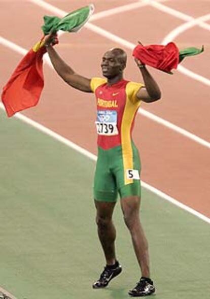 Francis Obikwelu pasea su alegría por el estadio con una bandera portuguesa en cada mano.