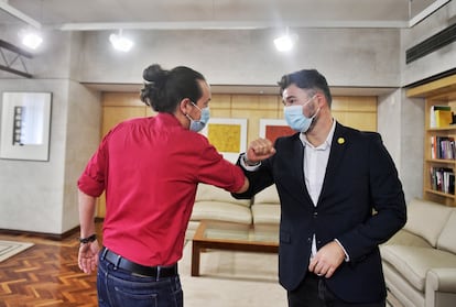 Pablo Iglesias y Gabriel Rufián se saludan con el codo en un encuentro en el Congreso de los Diputados.