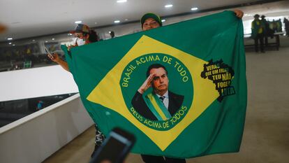 Una manifestante sostiene una bandera con la imagen de Bolsonaro, en el Palacio de Planalto.