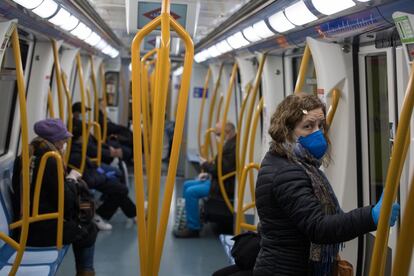 Usuarios del metro madrileño respetan la distancia social en el interior de uno de los vagones, este lunes.