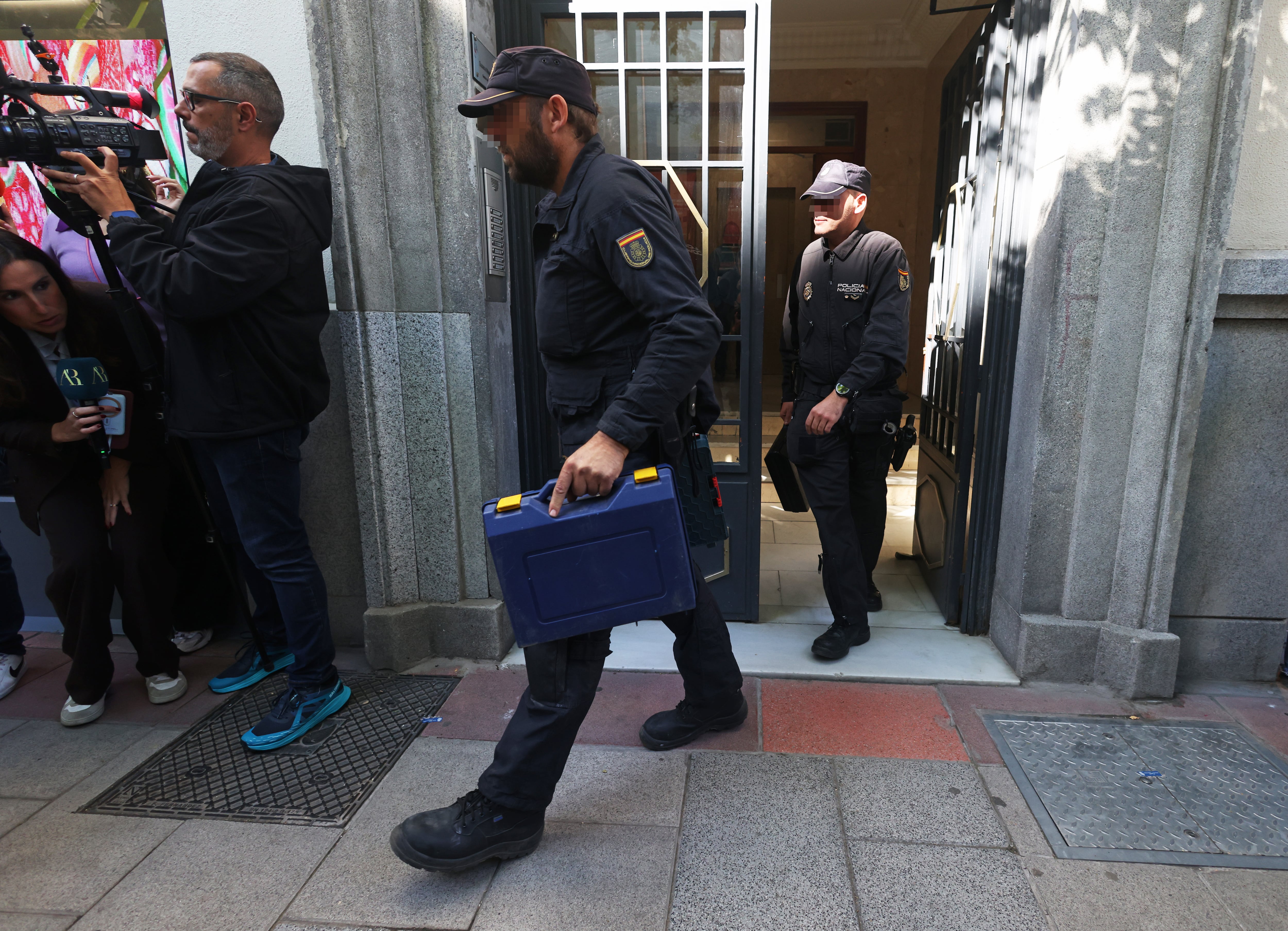 Agentes de la Policía Nacional tras el registro de la oficina del expresidente del Gobierno, José Luis Rodríguez Zapatero, en la calle Ferraz de Madrid. 
