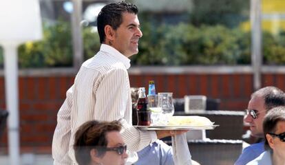 Un camarero sirve a los clientes en una terraza