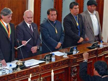 Evo Morales, frente a los miembros de la Mesa del Parlamento, jura su cargo con el puño izquierdo en alto.