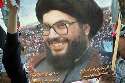 Seguidores de Hasan Nasralá, líder de Hezbolá, muestran un cartel con la imagen del dirigente.