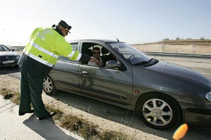 Un agente de la Guardia Civil pide la documentación a los ocupantes de un turismo.