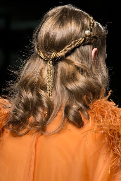 Dos trenzas confluyen y se renuevan con una cinta dorada que aporta el punto festivo justo y necesario para las ocasiones especiales. Una idea que vimos en el desfile de Atena Re para esta primavera.