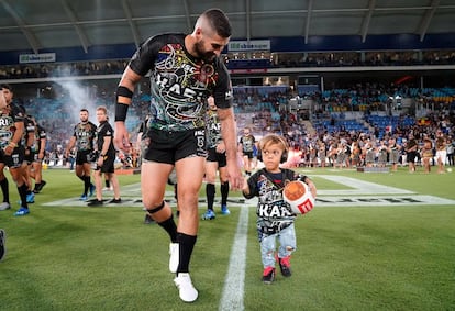 El capitán de los Maori Kiwis, Joel Thompson, junto a Quaden Bayle, de 9 años, que se hizo famoso por un vídeo que subió su madre denunciando el acoso que sufría en la escuela por su condición física. El niño hizo el saque inicial en el Cbus Super Stadium (Australia), el 24 de febrero.