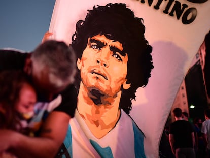 Pai abraça a filha durante manifestação no Obelisco de Buenos Aires em homenagem ao astro Diego Armando Maradona.