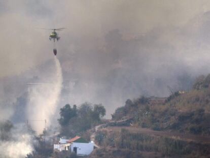 Un helicóptero echa agua sobre uno de los frentes próximos al municipio de San Mateo