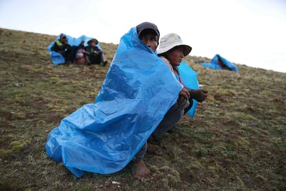 Las lluvias han llegado con meses de retraso a las comunidades altoandinas peruanas. Aunado a esto, caen granizadas cuando no es temporada y las temperaturas altas persisten durante varios meses. Todo esto perjudica a agricultores y ganaderos que, para salir adelante, se ven obligados a cambiar su tradicional calendario agrícola. En la imagen, un grupo de campesinos descansa bajo la lluvia durante la faena de volteo de la tierra de cultivo, el 14 de noviembre de 2023, en San José de Apata, en la provincia de Jauja (Perú).