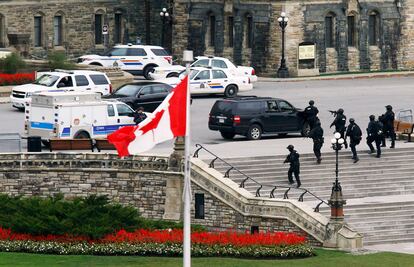 El presunto autor de los disparos en Ottawa contra un soldado y del ataque al edificio del Parlamento canadiense fue abatido por la Policía, que investiga si otras dos personas participaron en la acción. En la imagen, oficiales de policía en el exterior del Parlamento en Ottawa (Canadá).