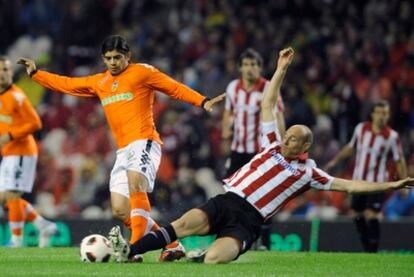 Toquero pelea un balón con Banega.