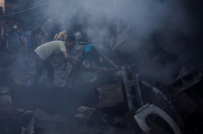 Palestinos buscan víctimas entre los restos de un edificio derruido tras un bombardeo israelí en Jan Yunis, al sur de la franja de Gaza. 