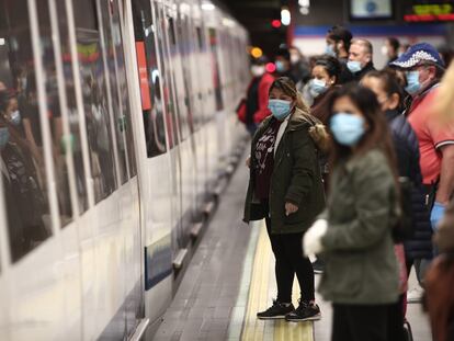 Viajeros con mascarillas en un andén de la estación de metro de Nuevos Ministerios