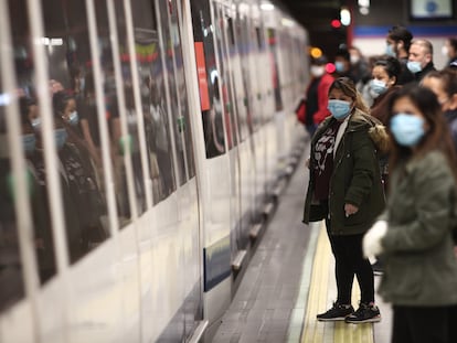 Viajeros con mascarillas en un andén de la estación de metro de Nuevos Ministerios este lunes.