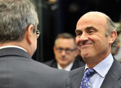 El presidente del Banco Central Europeo, Mario Draghi, habla con el ministro de Economía español, Luis de Guindos, este jueves en Luxemburgo.
