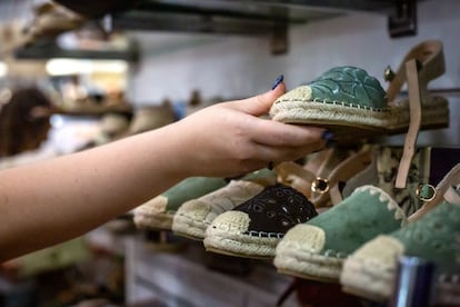 Una mujer contemplando los zapatos expuestos.