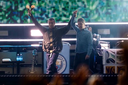Liam Gallagher agarra el brazo de su hermano Noel al principio del concierto de Cardiff, anoche en el Estadio Principality.