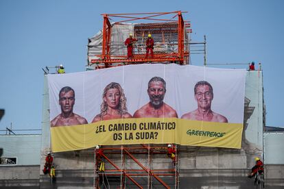 Activistas de Greenpeace despliegan la lona en la emblemática Puerta de Alcalá de Madrid.