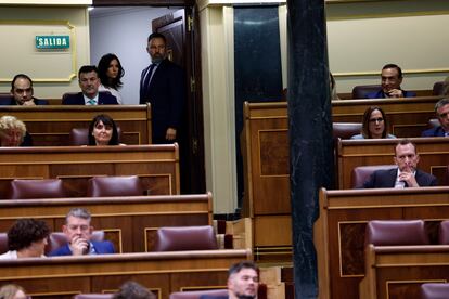 Santiago Abascal, tras abandonar su escaño, observa desde la puerta de salida del hemiciclo el pleno por la reforma del Reglamento del Congreso de los Diputados que permite el uso de las lenguas cooficiales.