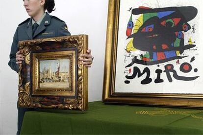 Una agente de la Guardia Civil sostiene el óleo falso de Édouard Manet delante del <i>miró</i> auténtico.