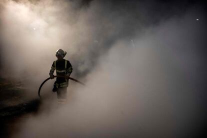 Un bombero apaga un incendio provocado por los guardias de la prisión que se manifestaron frente al edificio en Villefranche-sur-Saôneel (Francia).