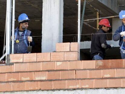 Tres obreros trabajan en la construcci&oacute;n de una vivienda. EFE/Archivo