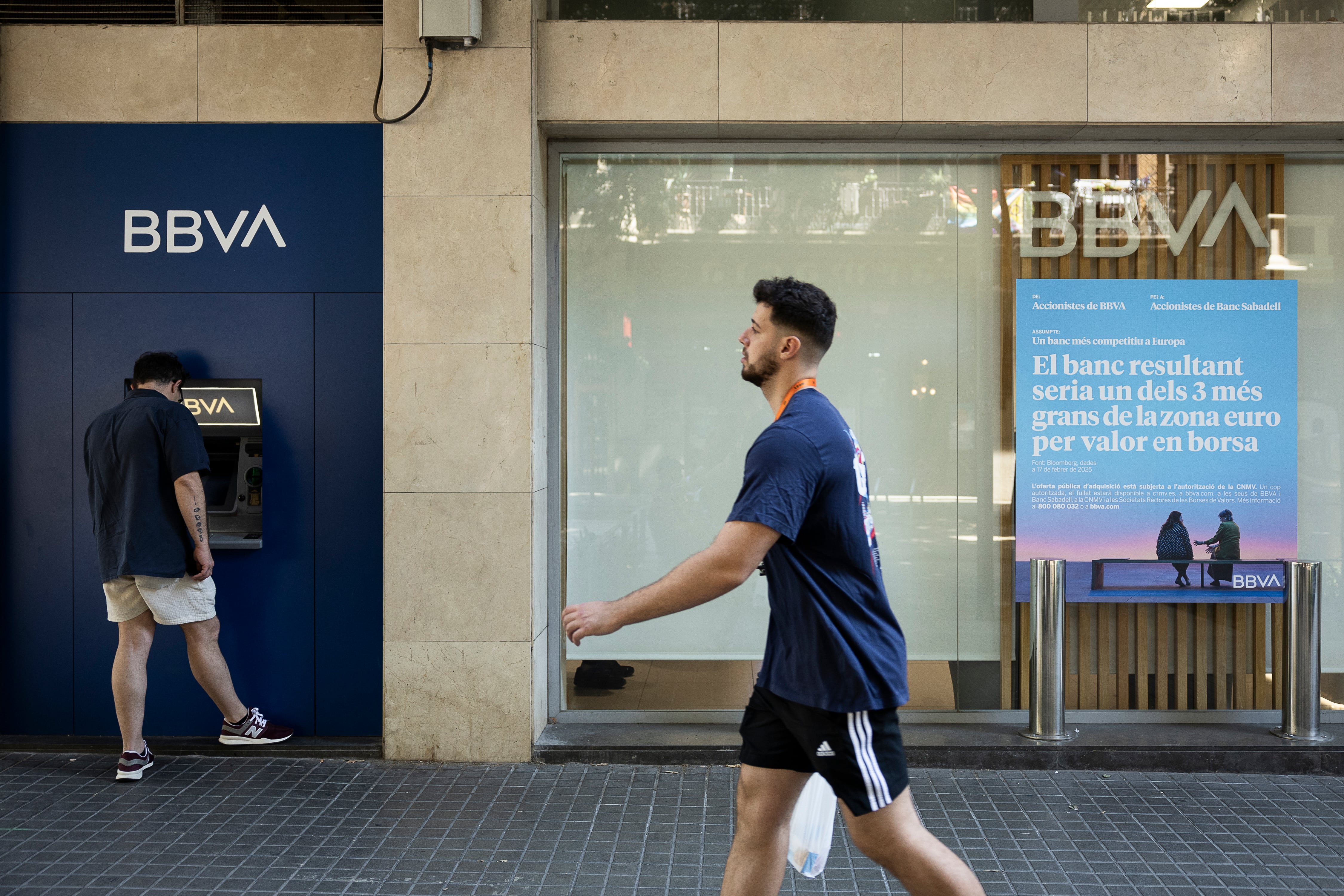 Un hombre saca dinero del cajero en una oficina bancaria del BBVA en Barcelona.