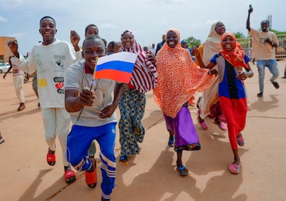 Supporters of Niger's ruling junta hold a Russian flag in Niamey, Niger, Sunday, Aug. 6, 2023