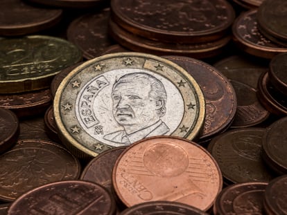 Focus on one euro coin with Juan Carlos I's face amidst eurocent coins. Royalty free stock photo.