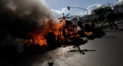 Protesters set fire to barricades in Brasilia using office furniture looted from ministry buildings.