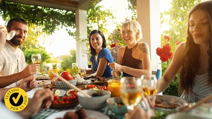 Un grupo de personas comiendo alrededor de una mesa al aire libre