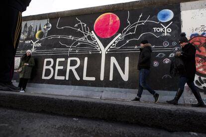 Un grupo de personas pasea frente al muro de Berlín, el 5 de febrero de 2018.