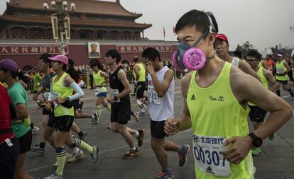 Un hombre corre en la marat&oacute;n de Pek&iacute;n de 2015 con una mascarilla anticontaminaci&oacute;n.