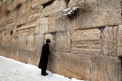 Un judío ultraortodoxo reza en el Muro de las Lamentaciones en la ciudad vieja de Jerusalén tras una nevada en 2022.