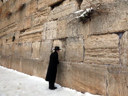 Un judío ultraortodoxo reza en el Muro de las Lamentaciones en la ciudad vieja de Jerusalén tras una nevada en 2022.