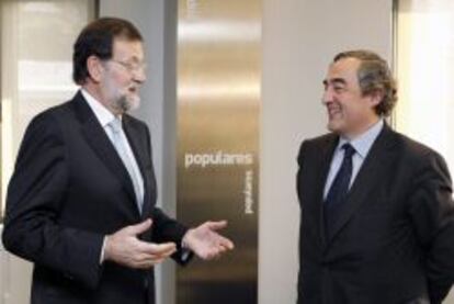 El presidente del Gobierno, Mariano Rajoy (i), conversa con el presidente de la CEOE, Juan Rosell, durante una reuni&oacute;n. 