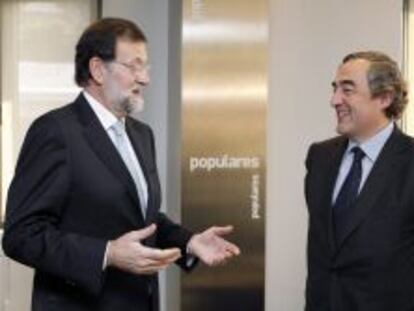 El presidente del Gobierno, Mariano Rajoy (i), conversa con el presidente de la CEOE, Juan Rosell, durante una reuni&oacute;n. 