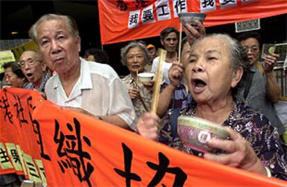 Unos manifestantes protagonizan una cacerolada con cuencos de arroz en contra el Gobierno de Hong Kong.