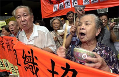 Unos manifestantes protagonizan una cacerolada con cuencos de arroz en contra el Gobierno de Hong Kong.