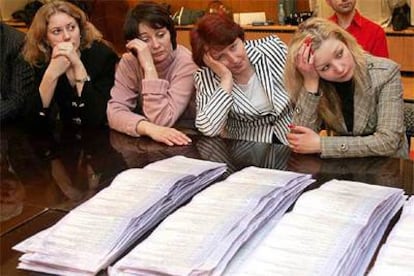 Miembros de la comisión electoral descansan durante el recuento de votos ayer en Kiev.