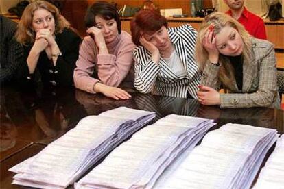 Miembros de la comisión electoral descansan durante el recuento de votos ayer en Kiev.