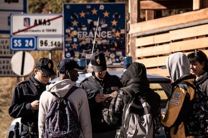 Varios policías italianos solicitan la documentación a tres migrantes, en la localidad fronteriza de Claviere (Italia), el 21 de octubre de 2018.