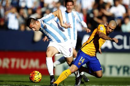 El delantero brasileño del Málaga Charles Dias (i) pelea por la pelota ante el centrocampista argentino del Barcelona Javier Mascherano (d).