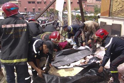 Los bomberos recogen cadáveres en el café Argana, el jueves tras el atentado.